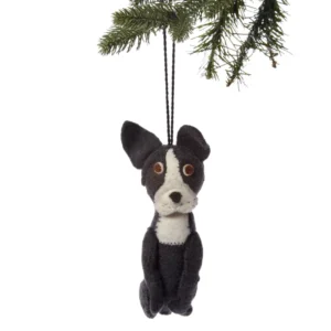 A black and white dog ornament hanging from a tree.