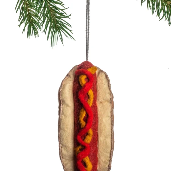 A hot dog ornament hanging on a tree.