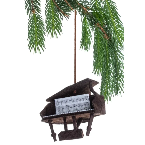 A piano ornament hanging from a tree branch.