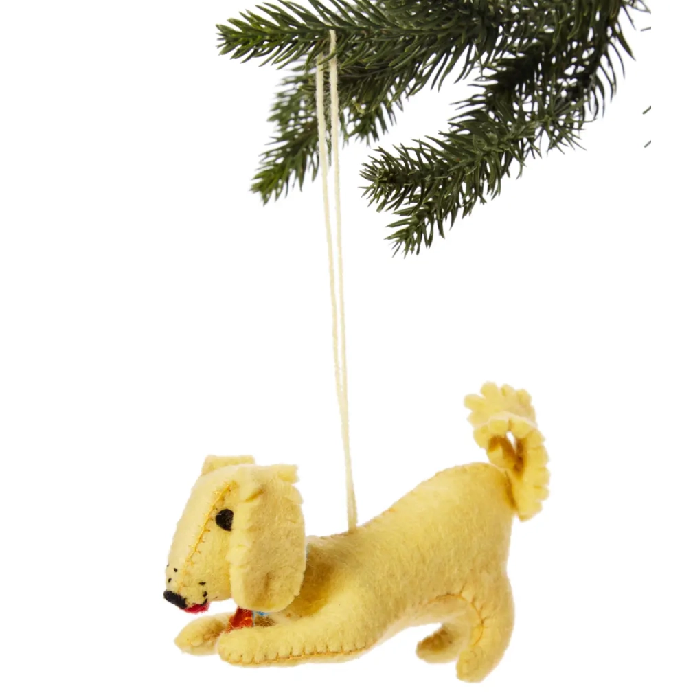 A yellow dog ornament hanging from a christmas tree.