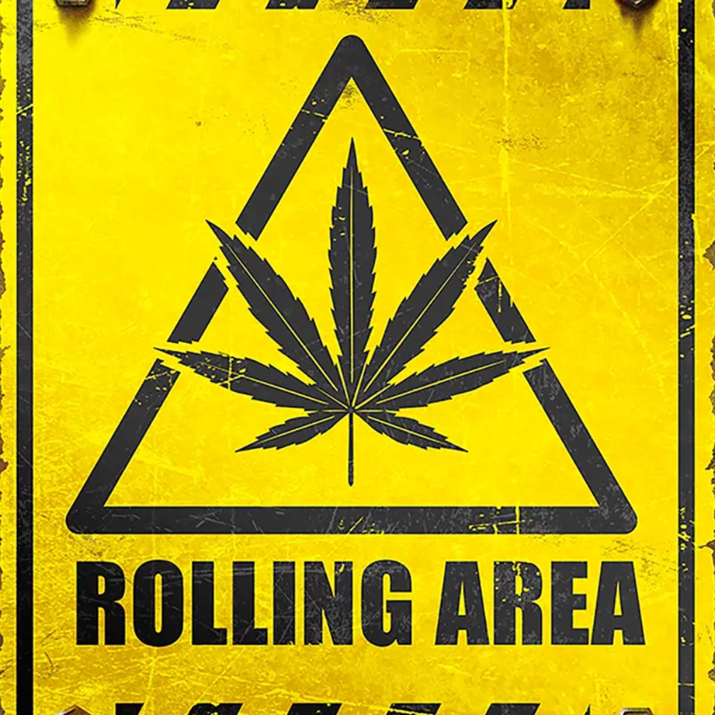 A yellow sign with a marijuana leaf on it.