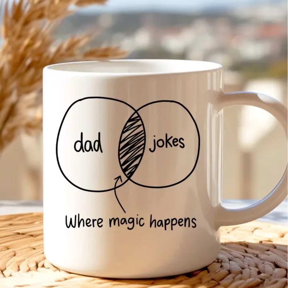 A coffee mug with the words dad jokes and where magic happens written on it.