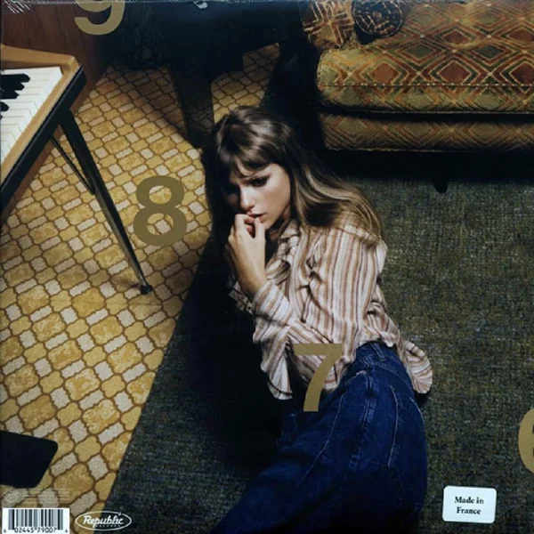 A woman sitting on the floor in front of a piano.